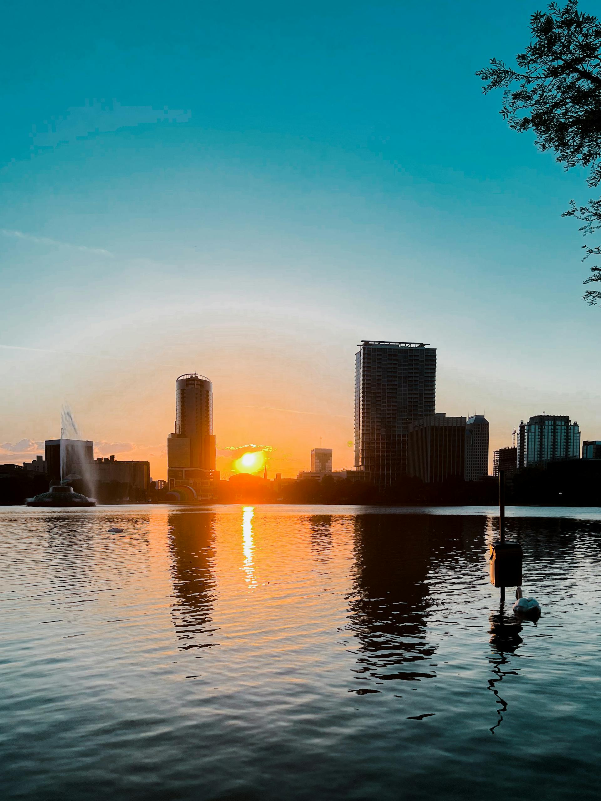 Stunning view of the Orlando skyline reflected in Lake Eola at sunset, capturing urban and natural beauty. HRD gives you the best options for orlando group hotel rates. 