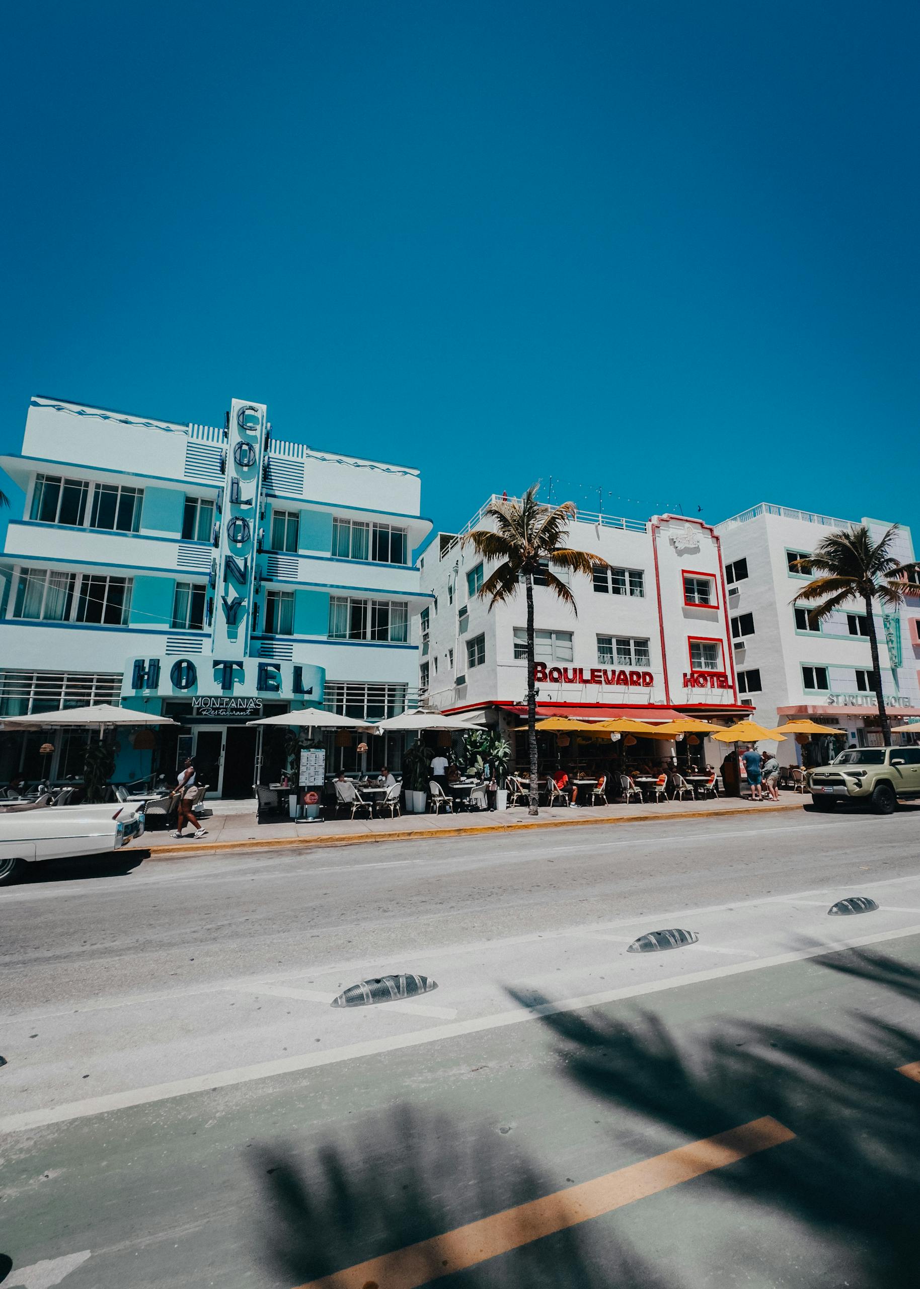 Colorful scene capturing Miami Beach's historic Ocean Drive with palm-lined street and iconic Art Deco hotels. Miami group hotel rates.