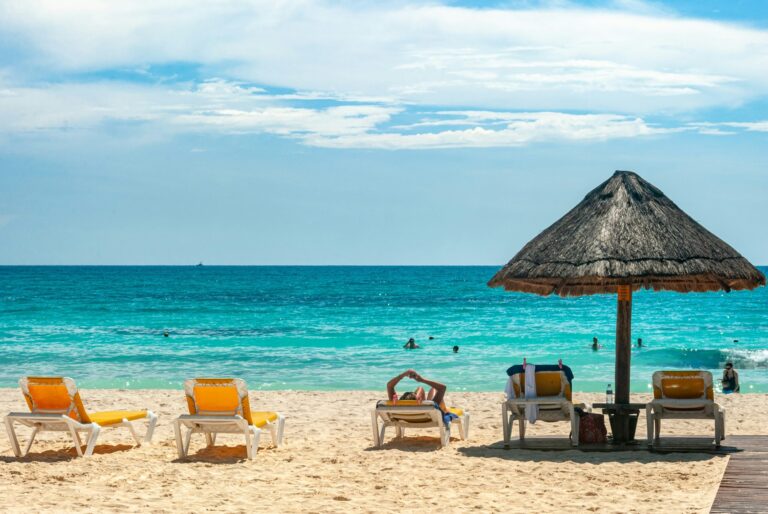beach chairs on the sand overlooking the water