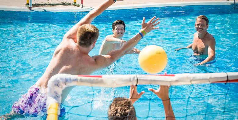 Sports team relaxing at their hotel pool after tournament games