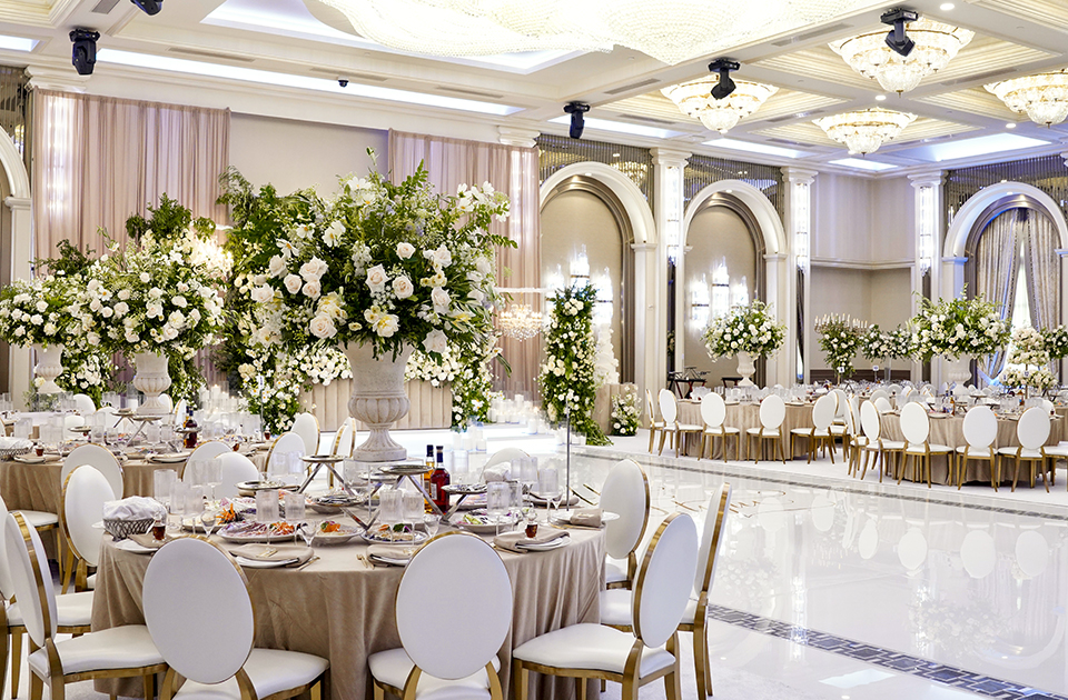 Luxury hotel wedding venue ballroom set for a reception with chandeliers